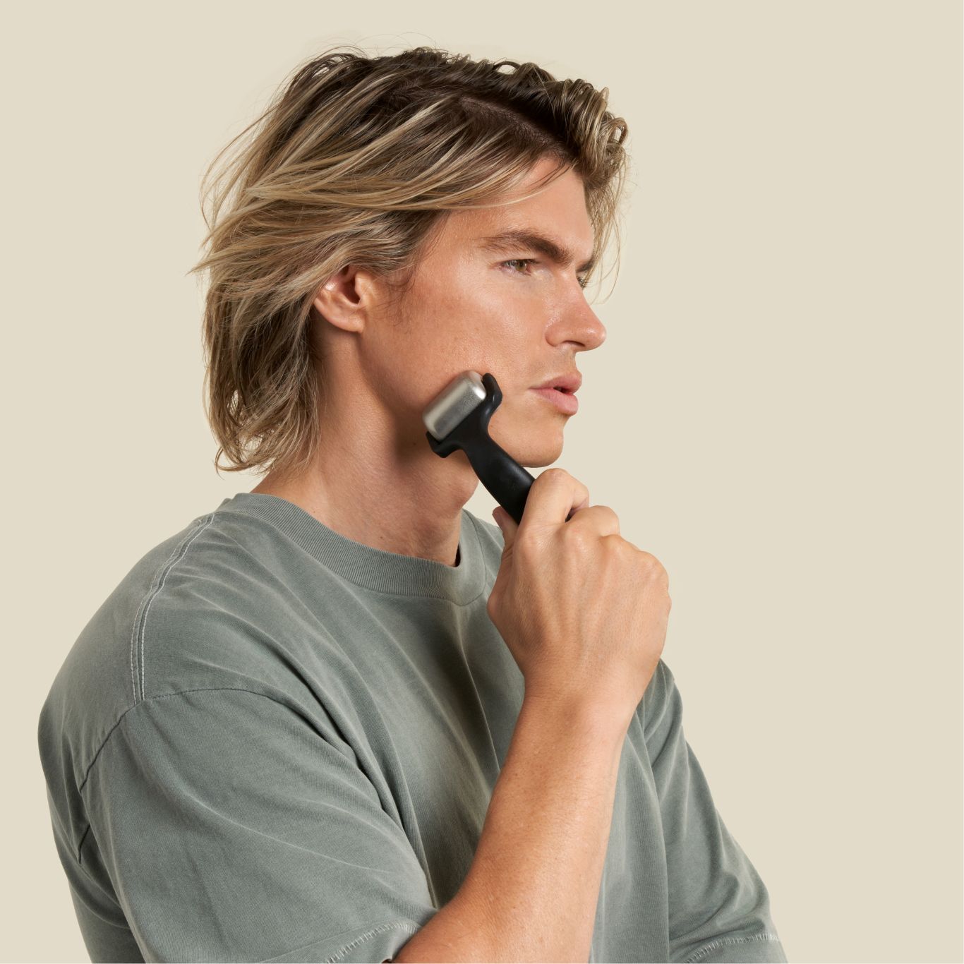 man using ice roller post facial exercise to sooth his muscles