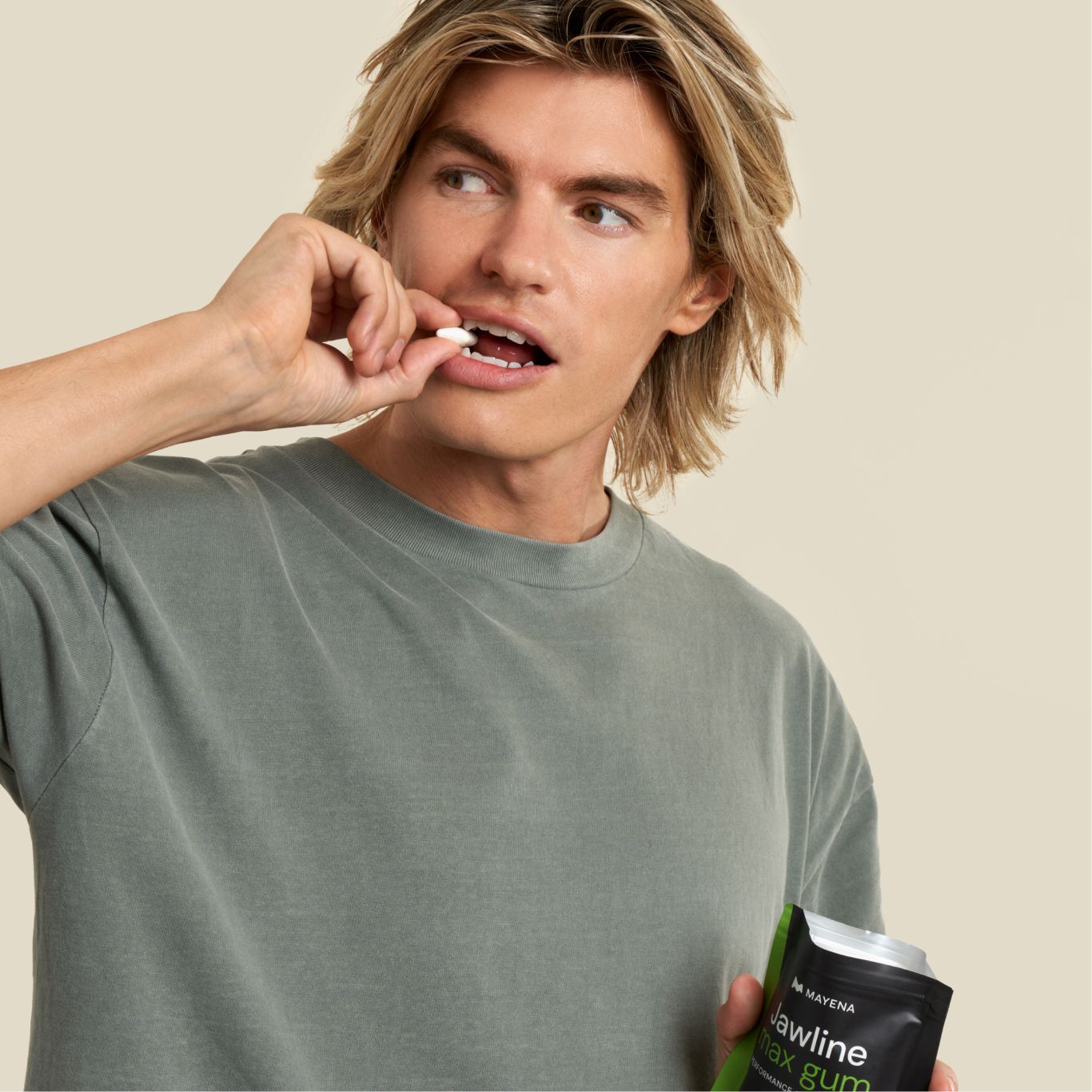 Man holding a package of Jawline gum and putting one in his mouth