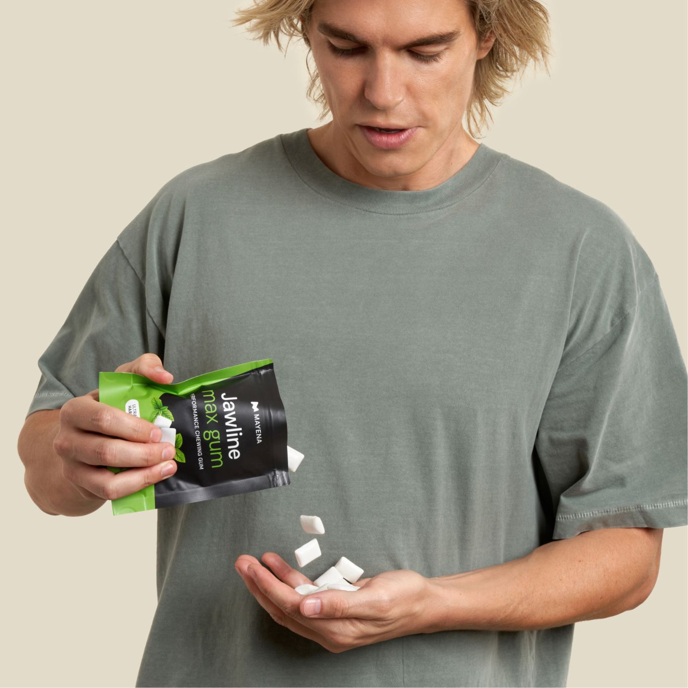 Man holding Jawline Max Mint gum pack and displaying the gum.