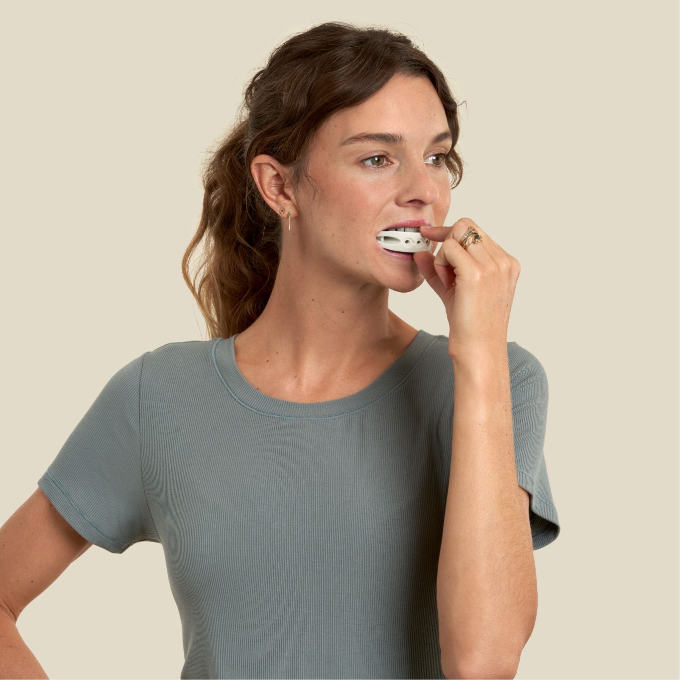 woman has a sand color full face trainer in her mouth