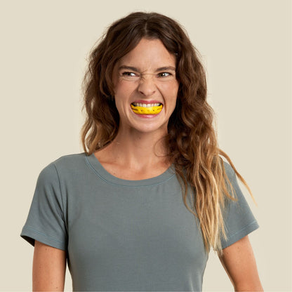 a woman is exercising her facial muscles using full face trainer yellow, level 2