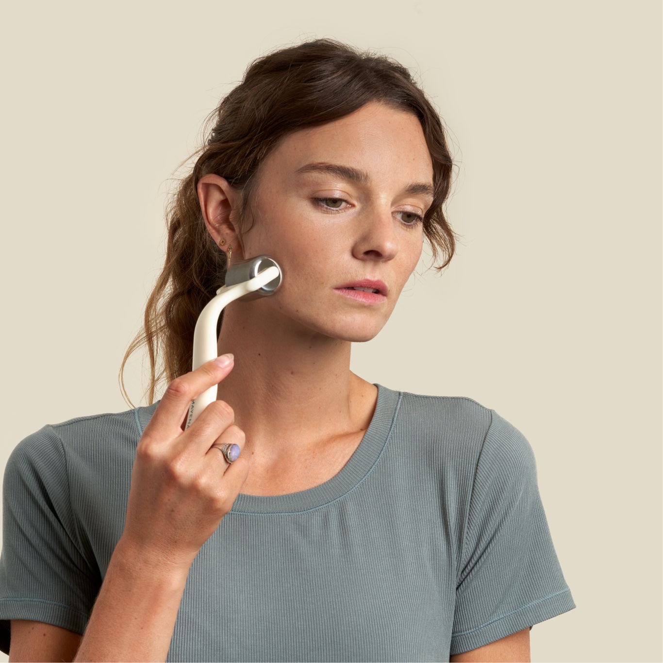 Woman using ice roller post facial exercise to sooth his muscles