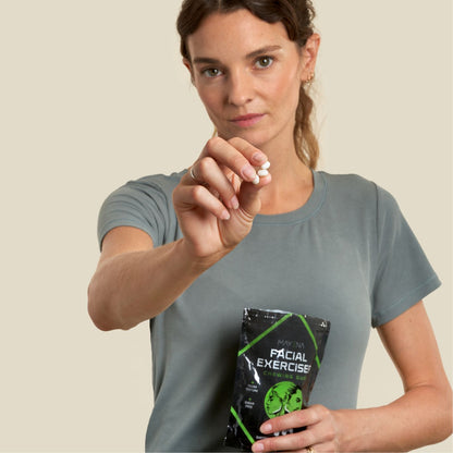 Woman holding a pack of customizable Facial Exerciser chewing gum, and displaying pieces in hand