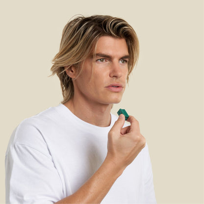 Sharp jawline man holding a jawline elite green pair prior to face exercising